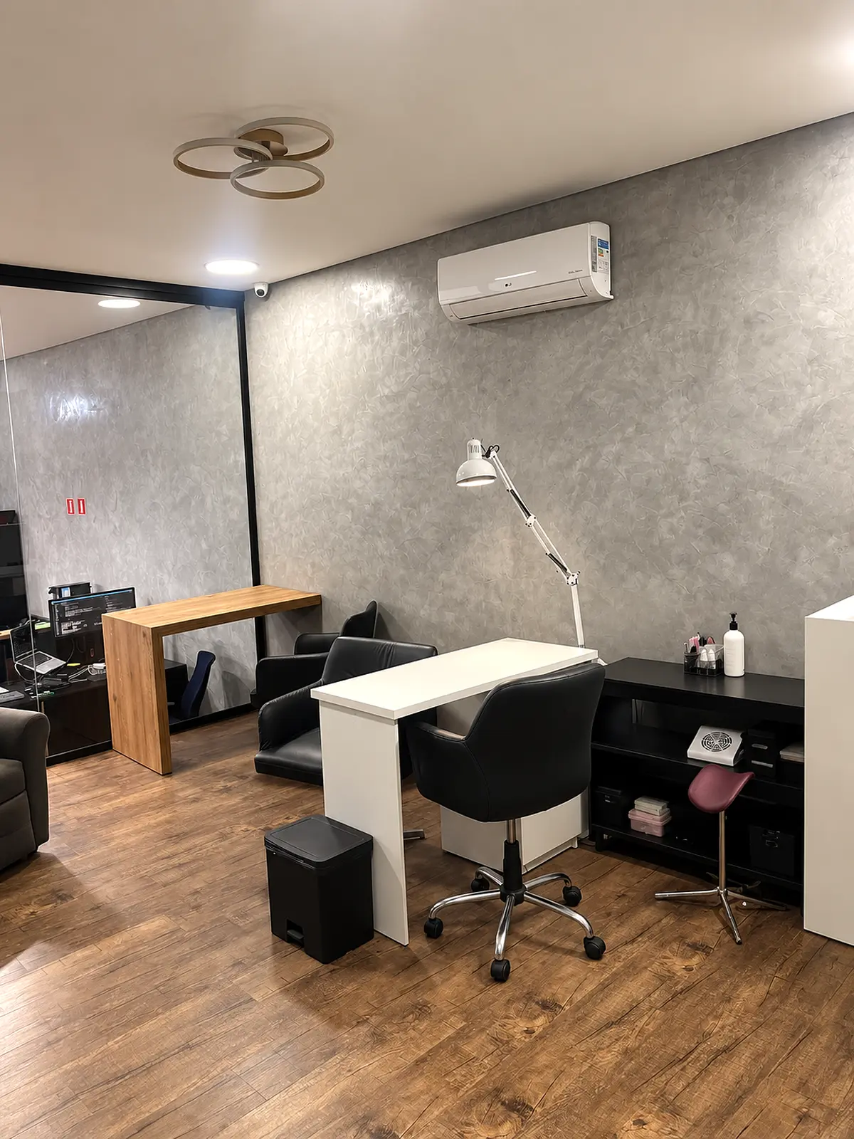 Sala de manicure e pedicure Lupin com mesa branca e cadeiras de atendimento